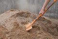 Pile of sand, hand of a construction worker scooping sand for mix mortar on construction site