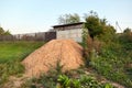 A pile of sand. A heap of building material for bedding or an ingredient for mixing cement. Green grass. Geological formation.