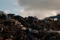 Pile of scrap metal at a junk yard with a metal structure on the side and a cloudy sky in the background Royalty Free Stock Photo