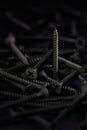 Pile of screws with flat head and phillips drive, in a dark key Royalty Free Stock Photo