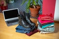 Pile of second hand clothing and shoes with computer on floor