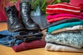 Pile of second hand clothing and shoes with computer on floor Royalty Free Stock Photo