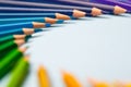 Pile of sharp coloured drawing pencils on table.