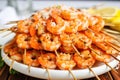 pile of shrimp skewers with white garlic butter pooled at the bottom