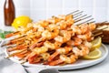 pile of shrimp skewers with white garlic butter pooled at the bottom