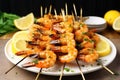 pile of shrimp skewers with white garlic butter pooled at the bottom