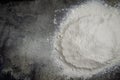Pile of sifted flour, dark concrete tabletop background. handful of white flour on black background