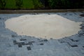 A pile of silica sand fraction 0-4 mm used as a material for backfilling the joints between the tiles of concrete gray interlockin