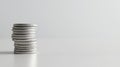 Pile of silver coins perched delicately on a shiny white surface, symbolizing wealth, financial planning, and prosperity Royalty Free Stock Photo