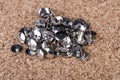 Pile of silver thumb tacks on a brown cork board Royalty Free Stock Photo