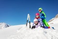 Pile of ski kids lay in snow on top mountain Royalty Free Stock Photo