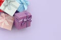 Pile of a small colored gift boxes with ribbons lies on a violet background. Minimalism flat lay top view Royalty Free Stock Photo