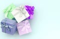 Pile of a small colored gift boxes with ribbons lies on a violet background. Minimalism flat lay top view Royalty Free Stock Photo