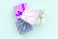 Pile of a small colored gift boxes with ribbons lies on a violet background. Minimalism flat lay top view Royalty Free Stock Photo