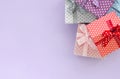 Pile of a small colored gift boxes with ribbons lies on a violet background. Minimalism flat lay top view Royalty Free Stock Photo