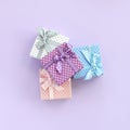 Pile of a small colored gift boxes with ribbons lies on a violet background. Minimalism flat lay top view Royalty Free Stock Photo