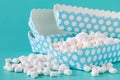 Pile of small colored puffy marshmallows on aquamarine