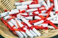 Pile of small paper scrolls in wicked basket. White scrolls tied with red ribbon. Future prediction, advice or sign concept