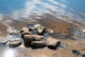 A pile of smooth stones on the sandy bottom of the river near the shore, background