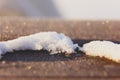 A pile of snow on a wooden surface shines in the sun. on a wooden surface. frosty Siberia