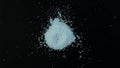 Pile of Sodium benzoate, sodium salt of benzoic acid on dark surface. White crystalline powder,