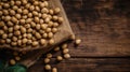 A pile of soya beans or soybean above the gunny sack, wooden background copy space studio presentation flat lay