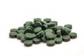 Pile of spirulina powder and capsules on white background Royalty Free Stock Photo