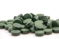 Pile of spirulina powder and capsules on white background Royalty Free Stock Photo