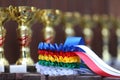 Pile of sport trophies and badges rosettes for the winners on show jumping competition