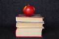 Pile stack of books with red apple on top, back to school concept, education concept, copy text space, black background Royalty Free Stock Photo