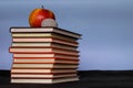 Pile stack of books with red apple on top sitting on a desk top, back to school concept, design concept, copy text space, blue Royalty Free Stock Photo