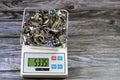 Pile stack of silver on a digital accurate scale in grams, bracelets, rings and silver chains, gold price concept, precious metal