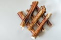 Pile of stacked Dried Bull pizzle. Bully sticks on light gray background. Shooting from top to bottom. Macro.