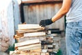 A pile of stacked firewood, prepared for heating the house. Gathering fire wood for winter or bonfire. Man holds fire wood in Royalty Free Stock Photo