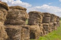 Pile of stacked large round straw bales. Straw bales in a stack on a beautiful summer day. Rolls of haystacks