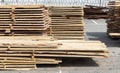 Pile of stacked wooden planks at a construction site. Wooden boards, lumber. Industrial edged timber. Wooden rafters for Royalty Free Stock Photo