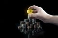 Pile of stacking coins with shiny golden bitcoin on top with grabbing hand, king of all coins, most valuable coin, rising Royalty Free Stock Photo