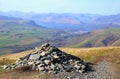 Pile of stones, or cairn, on Blencathra in the English Lake District, with Derwent Water in the distance Royalty Free Stock Photo