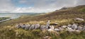 Pile of stones on a grass and beautiful view from Croagh Patrick, Westport, county Mayo, Ireland. Panorama image. Nobody. Irish Royalty Free Stock Photo