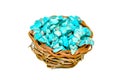 Pile stones of raw Turquoise in small wooden nest on a white background
