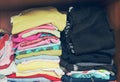 Pile of T-shirt clothes in closet. Stack of many color folded woman shirts overlay