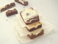 Pile of three marble chocolate brownies. Homemade dessert upon parchment. Square pieces of brownie cheesecake. Royalty Free Stock Photo