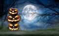 A pile of three spooky halloween pumpkin, Jack O Lantern, with an evil face and eyes on the grass Royalty Free Stock Photo