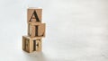 Pile with three wooden cubes - letters ALF for Always Listen First on them, space for more text / images on right side