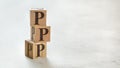 Pile with three wooden cubes - letters PPP meaning Praise Picture Push on them, space for more text / images at right side Royalty Free Stock Photo