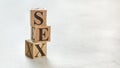 Pile with three wooden cubes - letters SEX on them, space for more text / images at right side