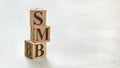Pile with three wooden cubes - letters SMB meaning Small to medium sized business on them, space for more text / images at right Royalty Free Stock Photo