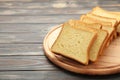 Pile of toasted bread slices on cutting board on brown background Royalty Free Stock Photo