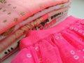 Pile of toddler cotton pink white clothes. Glittered tops and skirt.