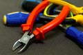 Pile of tools of hand red nippers on the background of plastic pens screwdriver macro background construction Royalty Free Stock Photo